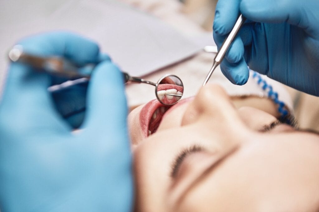 Advanced Medicine, Trusted Care. Attractive woman at the dental office. Dentist examining patient's teeth in clinic.